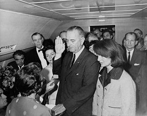 LBJ sworn in as 36th President on Air Force One, beside Kennedy's widow, Jacqueline.